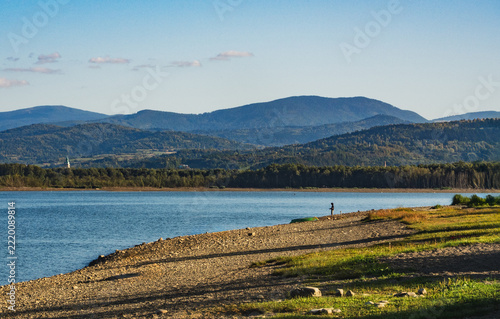 landscape beach by lake zarzecze (lake żywieckie) in poland, mountains in the background, lakeside view, structures and boats by the water., lake, 