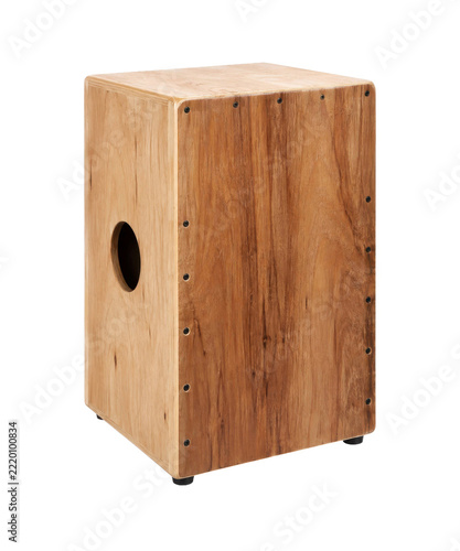 Fotografie Light brown wooden cajon, a percussion instrument, stands upright with a circula