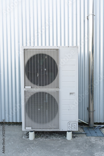 Industrial outdoor air conditioner unit mounted on a metal wall facade