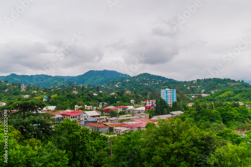 Clouds over small town and the mountains with green trees, rural houses - overcast, cloudy. Georgian landscape near Batumi in Georgia. Summer and nature concept
