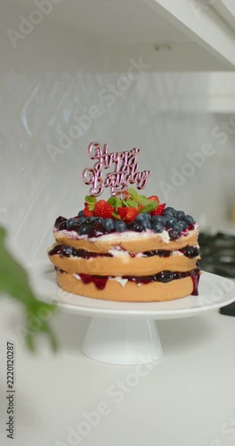 Vertical video: Camera is sliding and centering cake on pedestal to reveal jam drips and topper
