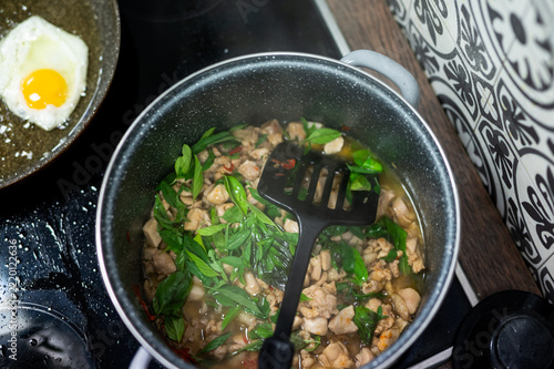 Finished Thai Pad Kra Pao chicken with basil in a cooking pot