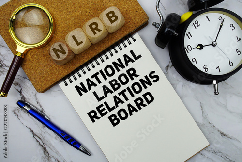 NLRB National Labor Relations Board text written on notepad with calculator and magnifying glass on marble background