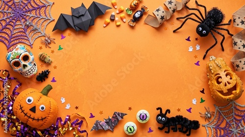 Creative Halloween Flat Lay Border with Spooky Decorations on Bright Orange Surface