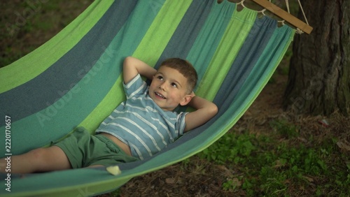 Little Boy Lying in a Hammock and Gently Swinging in Nature, Close Up