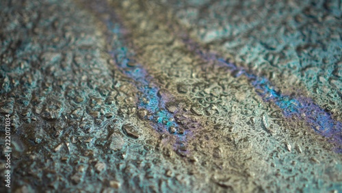 Colorful Gasoline Film Spreads Across Wet Asphalt. Rainbow Fuel Reflection on the Road