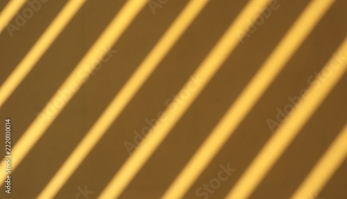 Colorful paper sheets with dramatic linear fence shadows cast by warm natural sunlight