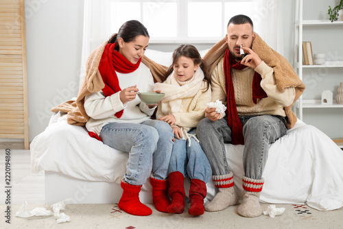 Ill family with plaid treating cold in bedroom