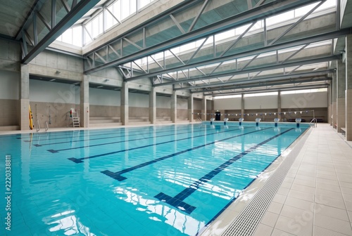 Still turquoise water in an empty indoor swimming pool