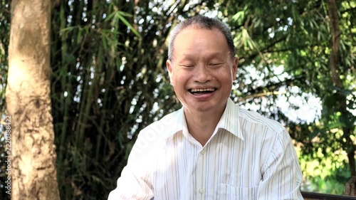 Slow Motion Portrait of Happy Thai Senior Man Laughing in Bamboo Garden