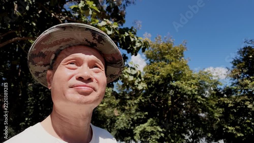 Slow Motion Low Angle Portrait of Thai Senior Man Turning to Smile at Camera