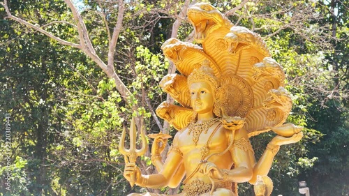 Slow Motion Panning Shot of Golden Lord Vishnu Statue in Forest