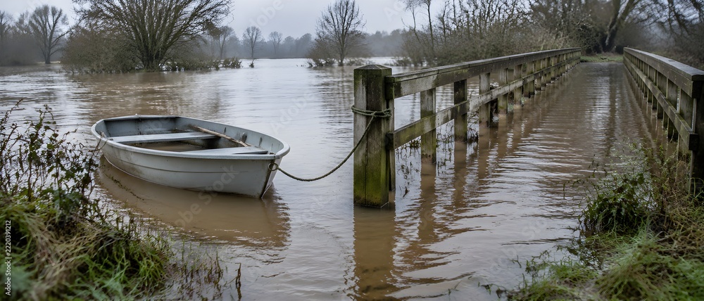 Obraz premium Small rowing boat tied with a slack line to a flooded footbridge