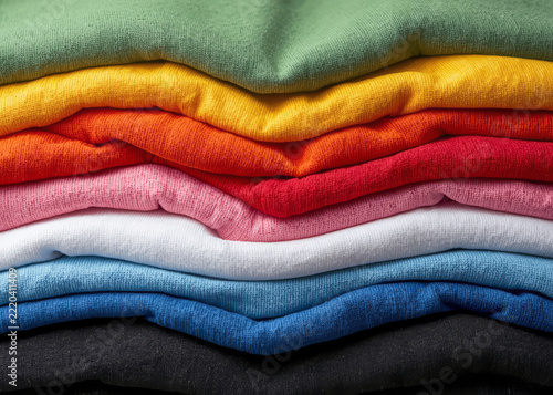 Multicolored towels, stacked and overlapping, form a pattern.
