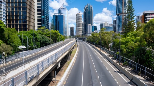 Modern Cityscape Featuring Empty Road and Skyscrapers Under Clear Blue Sky