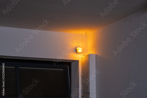 Wall mounted light and ventilation grille in building interior