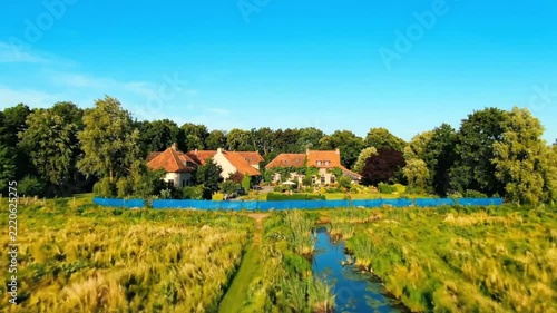 Aerial view of a rustic farmhouse surrounded by lush greenery and fields