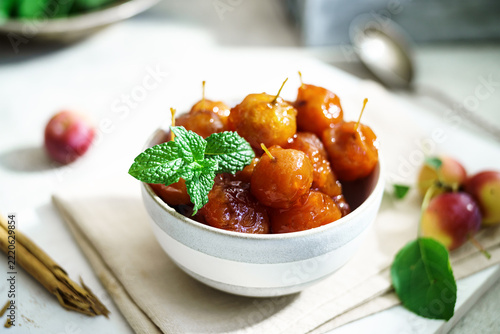 Bowl of candied crabapples garnished with fresh mint leaves