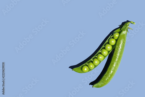Pod of peas against light blue background
