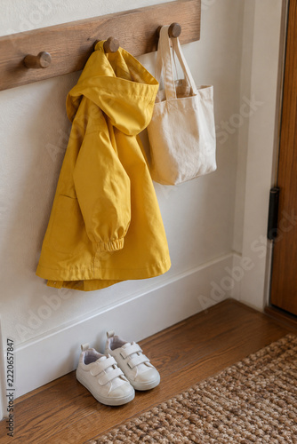 Child height coat hooks with a small jacket and canvas bag