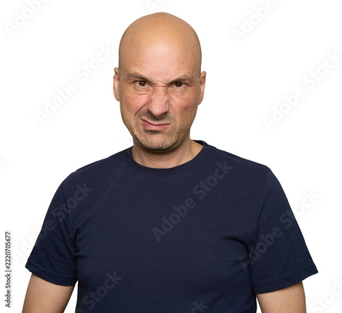 Serious bald man in dark blue t-shirt looking displeased