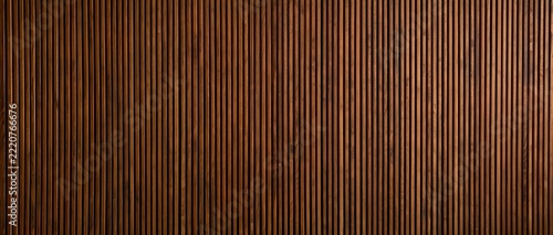 Rich brown wooden wall panel with vertical acoustic grooves showcasing natural grain and texture under soft warm lighting for interior design and architectural applications