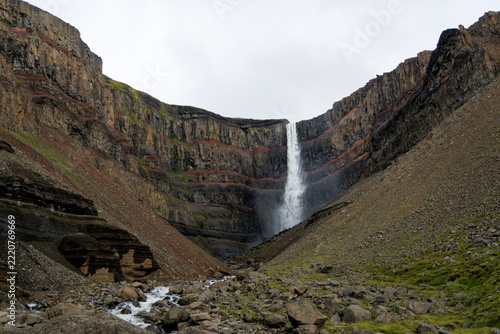 Hengifoss waterfall in a cliff with red clay layers