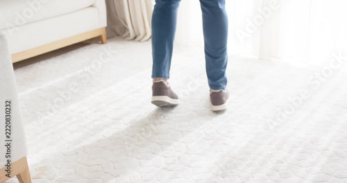 With weight shift initiating motion legs and feet are taking steps across rug while balancing