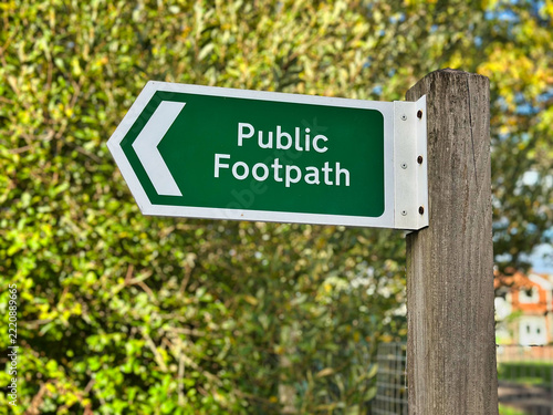 British Green Public Footpath Directional Sign on Wooden Post