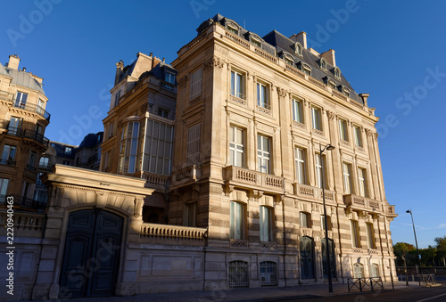 Corner facade of an ornate stone building with bay window and mansard roof , 7th arrondissement, Paris, France