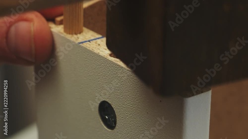 Human hands use a screwdriver to screw bolts into furniture