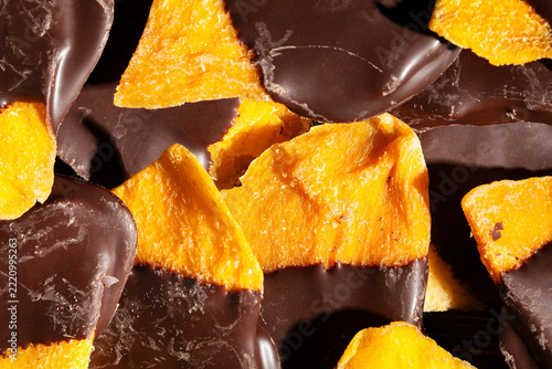 chocolate dipped mango on black background top view