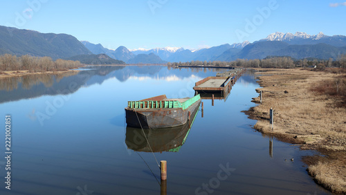 Anchored barges reflected in mirror-like river