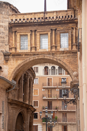 Historic stone archway framing traditional residential building in Valencia, Spain