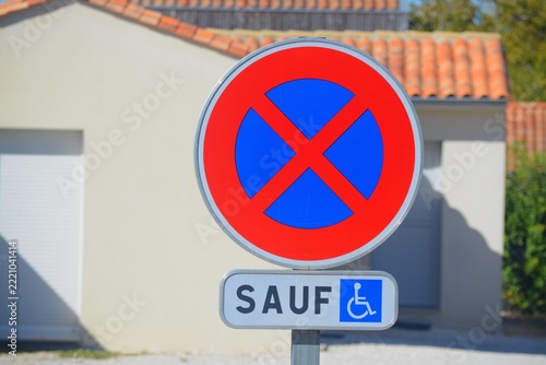 Panneau de signalisation : interdit de s'arrêter sauf pour les handicapés.