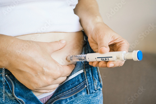 Woman self-administering GLP-1 medication injection into abdomen