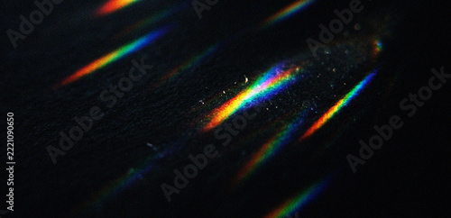 Abstract light streaks with rainbow spectral dispersion on a dark background