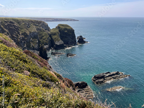 Obraz na plátně Anglesey, Wales: Rugged sea cliffs and rock stacks rise from calm blue-green wat