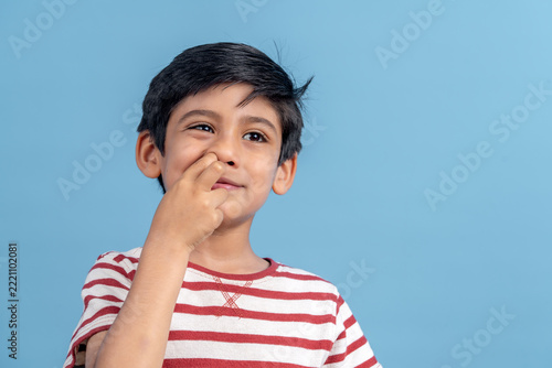 Young boy picking nose, expressing silly emotion
