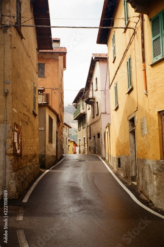 Narrow Village Street Winding Between Ochre Buildings, Italy