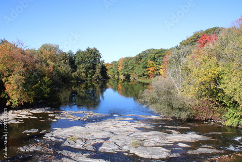 Trees in fall foliage reflecting on Yamaska River