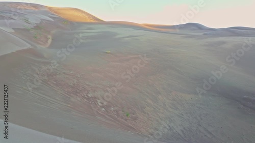 Golden morning sunlight crests towering ridges of sand in Great Sand Dunes National Park