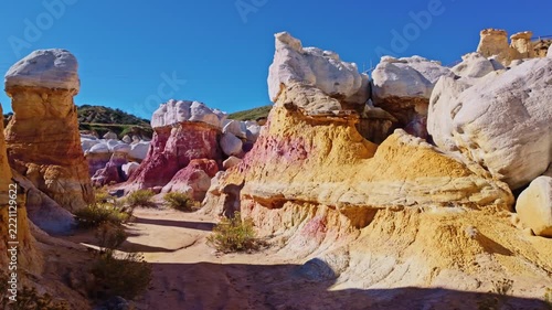 Towering white-capped hoodoo rock formations rise against a vibrant blue sky at Paint Mines Interpretive Park in Calhan, Colorado
