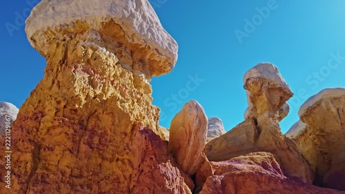 Towering white-capped hoodoo rock formations rise against a vibrant blue sky at Paint Mines Interpretive Park in Calhan, Colorado