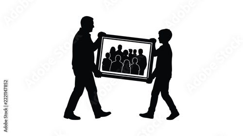 Black silhouette of father and son walking together while carrying large family picture frame
