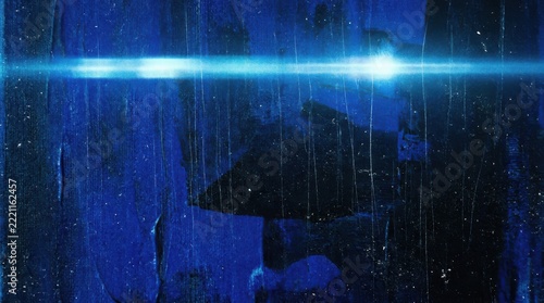 Abstract blue light streaks and texture with a shadowy human silhouette against a dark background