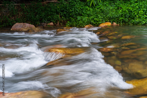 Beautiful tropical waterfall flowing over rocks in a lush green forest in Saraburi, Thailand, creating a fresh and refreshing natural garden landscape, clear and clean motion water in nature rapids