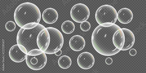 A collection of delicate iridescent soap bubbles floating against a dark gradient background