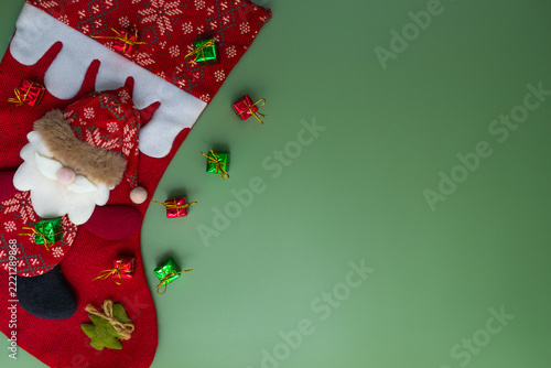 Christmas stocking with gifts on green background