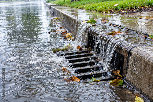 Rainwater Flowing into Storm Drain on Wet Street